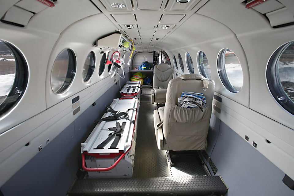 Interior of King Air air ambulance, two seats and a long medical bed.