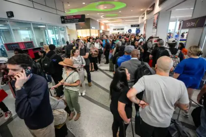 A crowd of people waiting inside a busy airport
