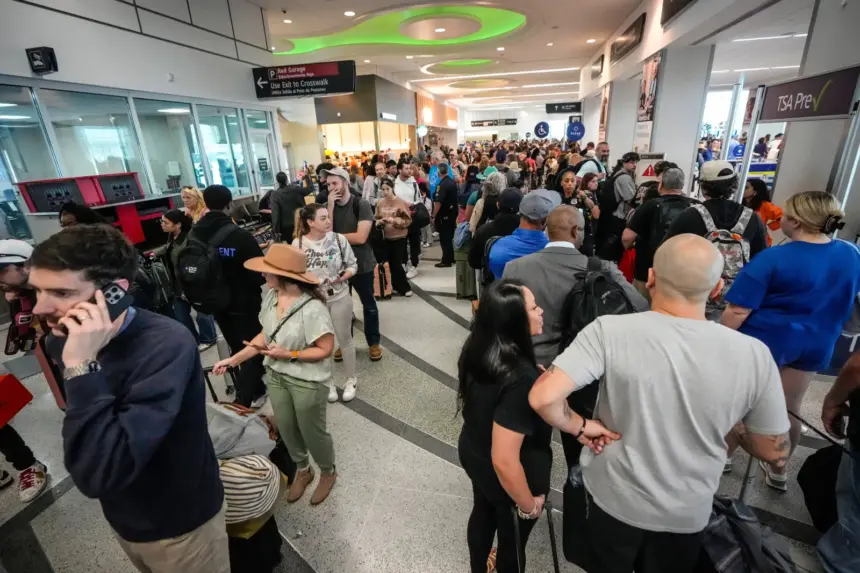 A crowd of people waiting inside a busy airport