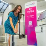lady checking in her bag with new bag tag station