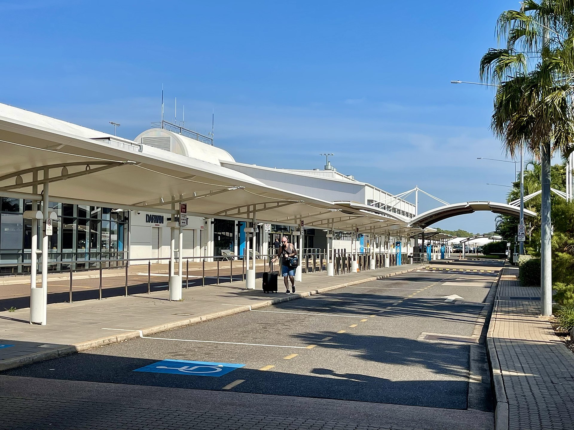 Outside of Darwin International Airport in a sunny day with some palm trees
