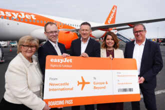easyJet representatives with a large boarding pass labelled 'From Newcastle to Europe and beyond'