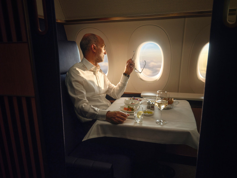 Passenger has a FOX Lufthansa Main Course tasting, as he stares out of the window.