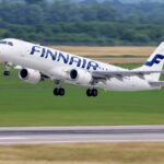 Embraer Finnair aircraft taking off. Blue and white livery.