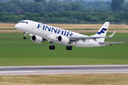 Embraer Finnair aircraft taking off. Blue and white livery.