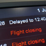Flight board showing delayed flights in red at the airport