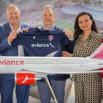 Avianca and Miami FC representatives stand with model aircraft and new sports jersey donning Avianca logo