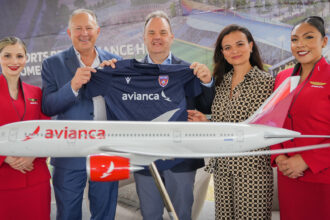 Avianca and Miami FC representatives stand with model aircraft and new sports jersey donning Avianca logo