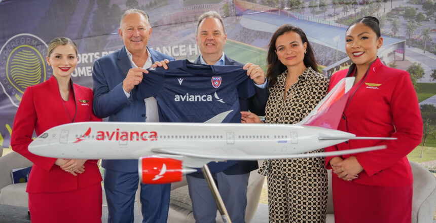 Avianca and Miami FC representatives stand with model aircraft and new sports jersey donning Avianca logo