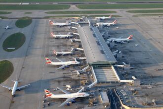 Aerial view of Heathrow Airport Terminal 5 in London. Numerous British Airways aircraft are parked at the gates