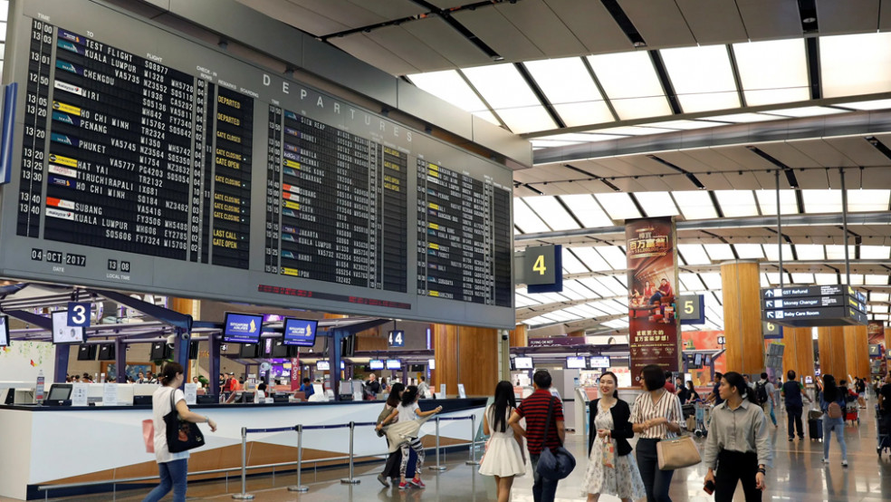 Interior of Manila airport, flight screen visible, people gathering. From March 29 the airport will reshuffles some of the terminals to ease congestion.