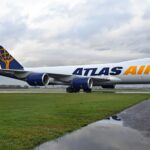 Atlas Air Boeing 747-8F on the runway surrounded by grass.