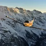 Pilatus PC-12 PRO aircraft flying through the snowy mountains.