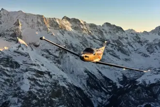Pilatus PC-12 PRO aircraft flying through the snowy mountains.