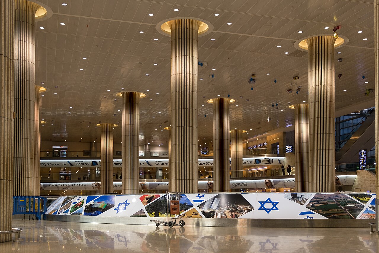 Photograph of the inside of the Tel Aviv Airport, we can see Israeli flags and photos of the country