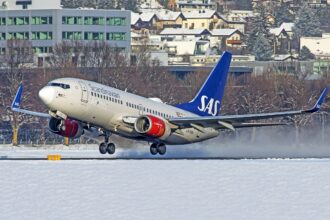 Scandinavian Airlines Boeing 737-700 landing on snowy ground.