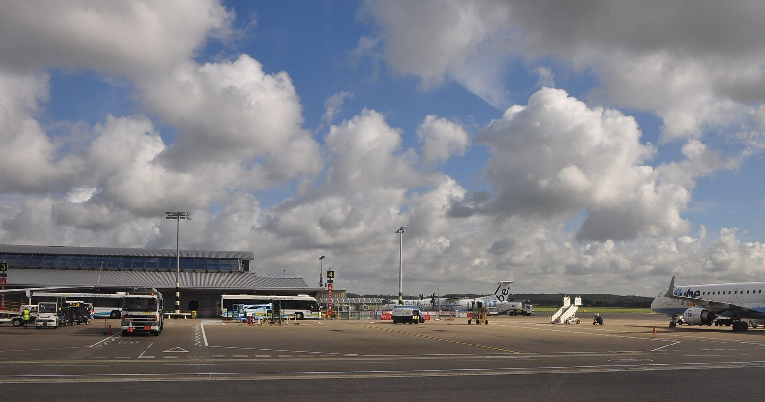 Image shows Southampton Airport during a cloudy day with vehicles and aircraft present