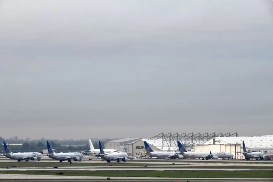 Grounded planes at an airport, grey sky.