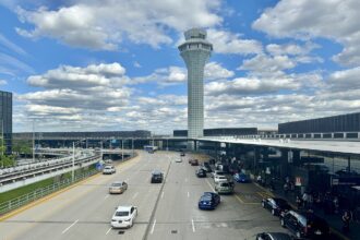 Cars queue at O'Hare terminal drop-off as FAA proposes flight cuts affecting passengers.