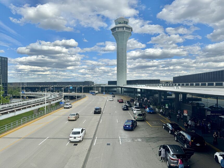 Cars queue at O'Hare terminal drop-off as FAA proposes flight cuts affecting passengers.