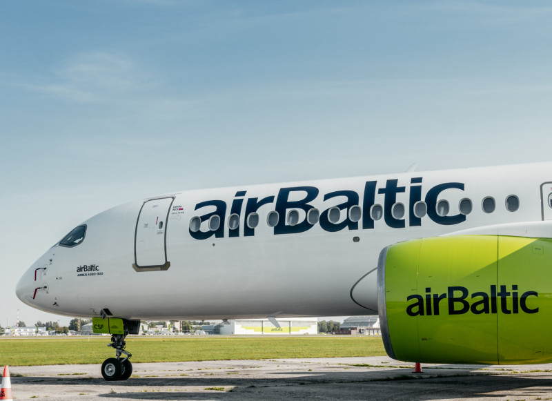 airBaltic AirbusA220 aircraft stationed on a runway