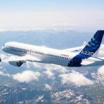 Airbus stretched A220 aircraft, flying through the clouds.