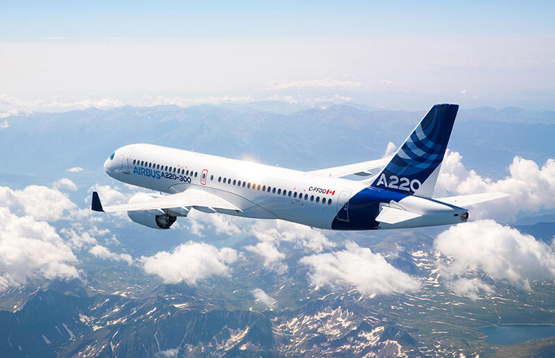 Airbus stretched A220 aircraft, flying through the clouds.
