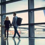 An image of people looking out of an airport window at a SAS aircraft