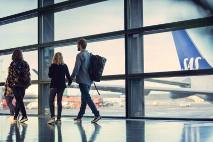 An image of people looking out of an airport window at a SAS aircraft