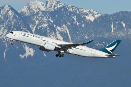 A Cathay Pacific plane taking off with a backdrop of mountains
