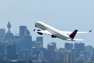 A Delta plane taking off, city in the background.