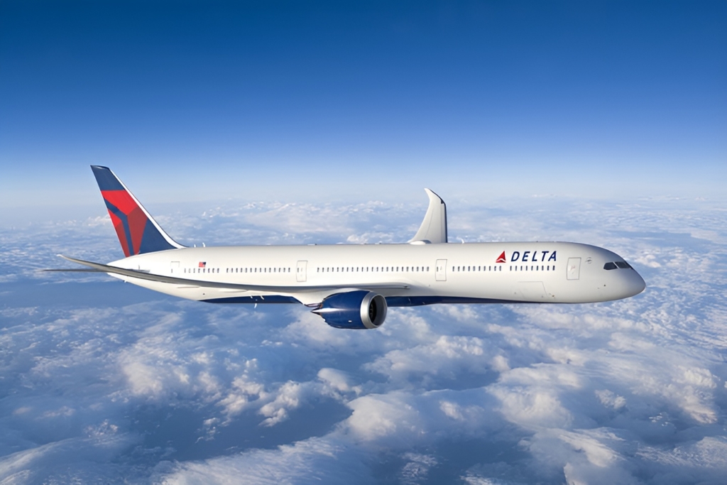 A Delta Airlines aircraft flying above the clouds below through blue skies.