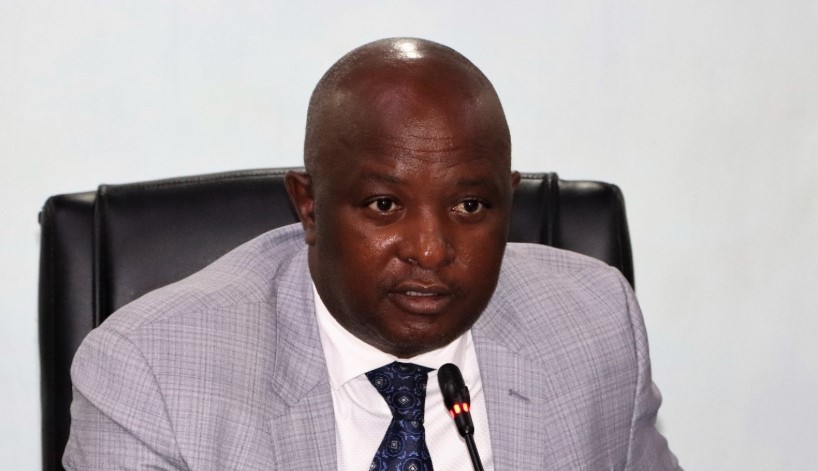  Vihiga Senator Godfrey Osotsi, speaking publically. Sat on a black chair, with a grey suit.