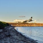 An Air New Zealand plane landing near the coast.
