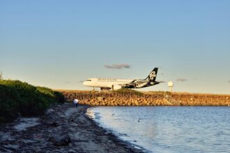 An Air New Zealand plane landing near the coast.