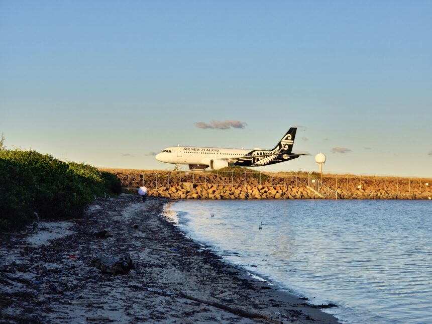 An Air New Zealand plane landing near the coast.