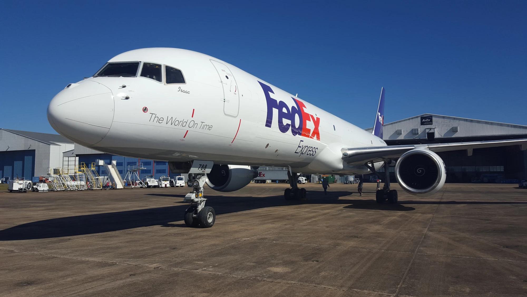 FedEx aircraft on the ground among clear blue skies and a long piece of tarmac