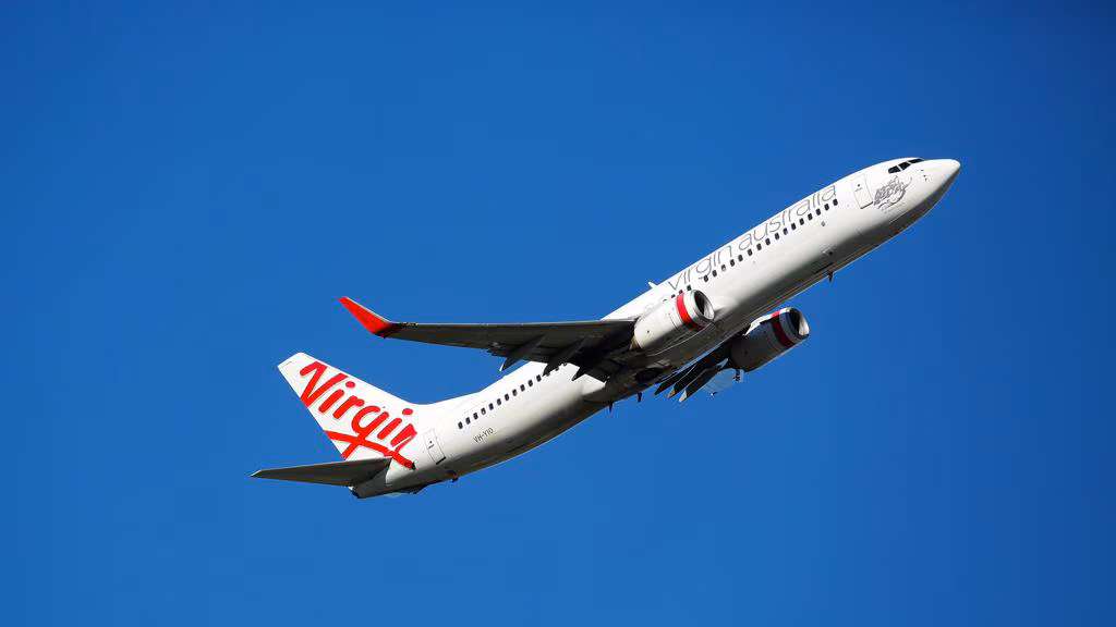 Virgin Australia aircraft, flying upwards, blue sky in background.
