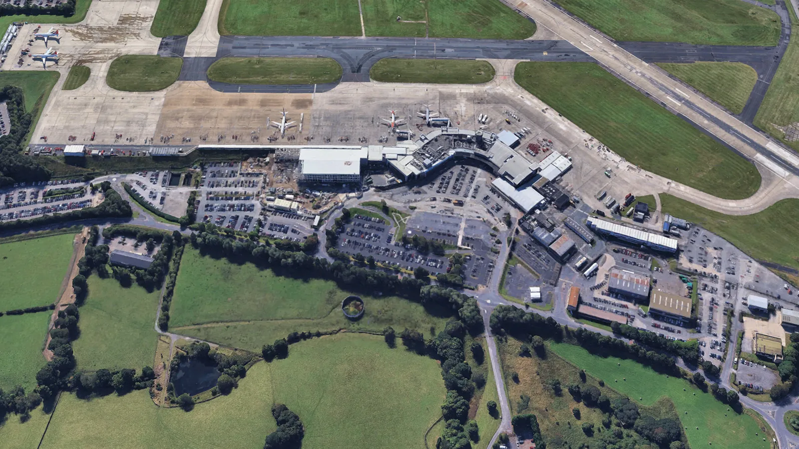 A google maps aerial view of Leeds Bradford Airport among fields, with roads running into the main building.