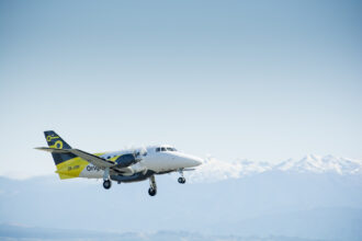 Originair aircraft flying under a blue sky
