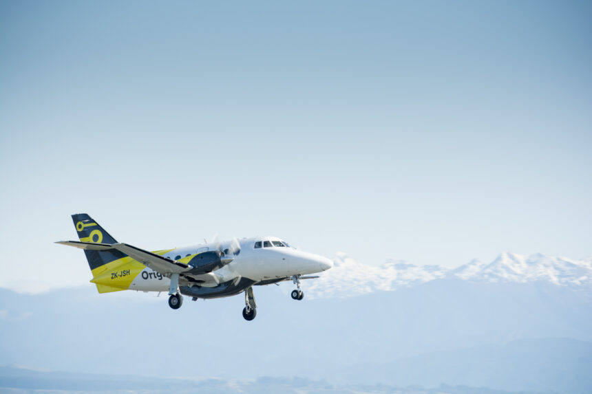 Originair aircraft flying under a blue sky