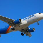 A large passenger plane flying through a blue sky