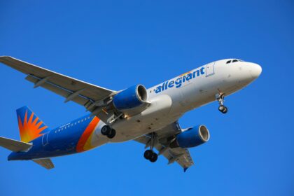 A large passenger plane flying through a blue sky