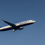 A large jetliner in flight in a blue sky