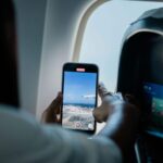 A person recording video out of a plane window