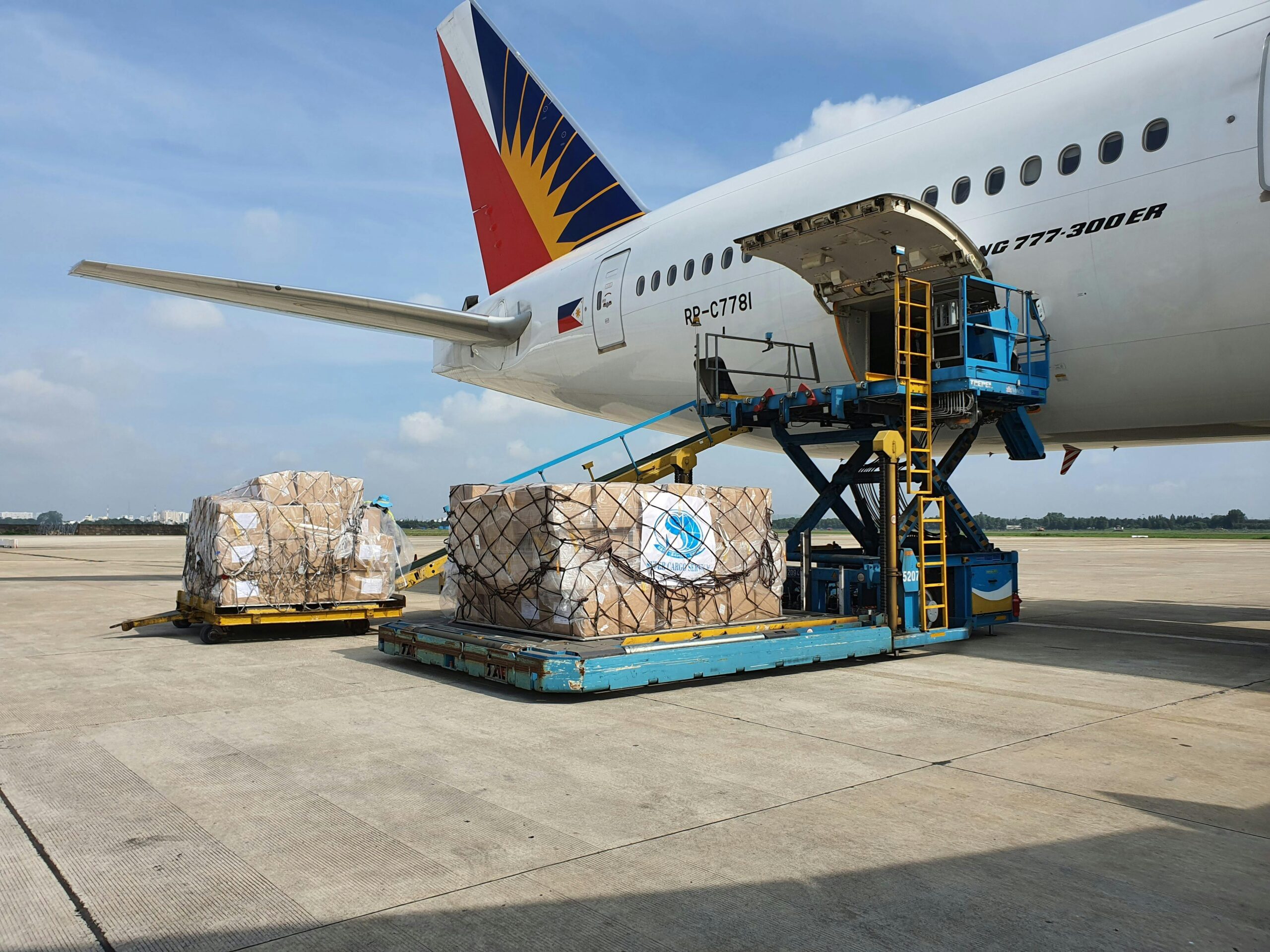 Boxes being loaded onto a cargo plane showing the flag of the Philippines.