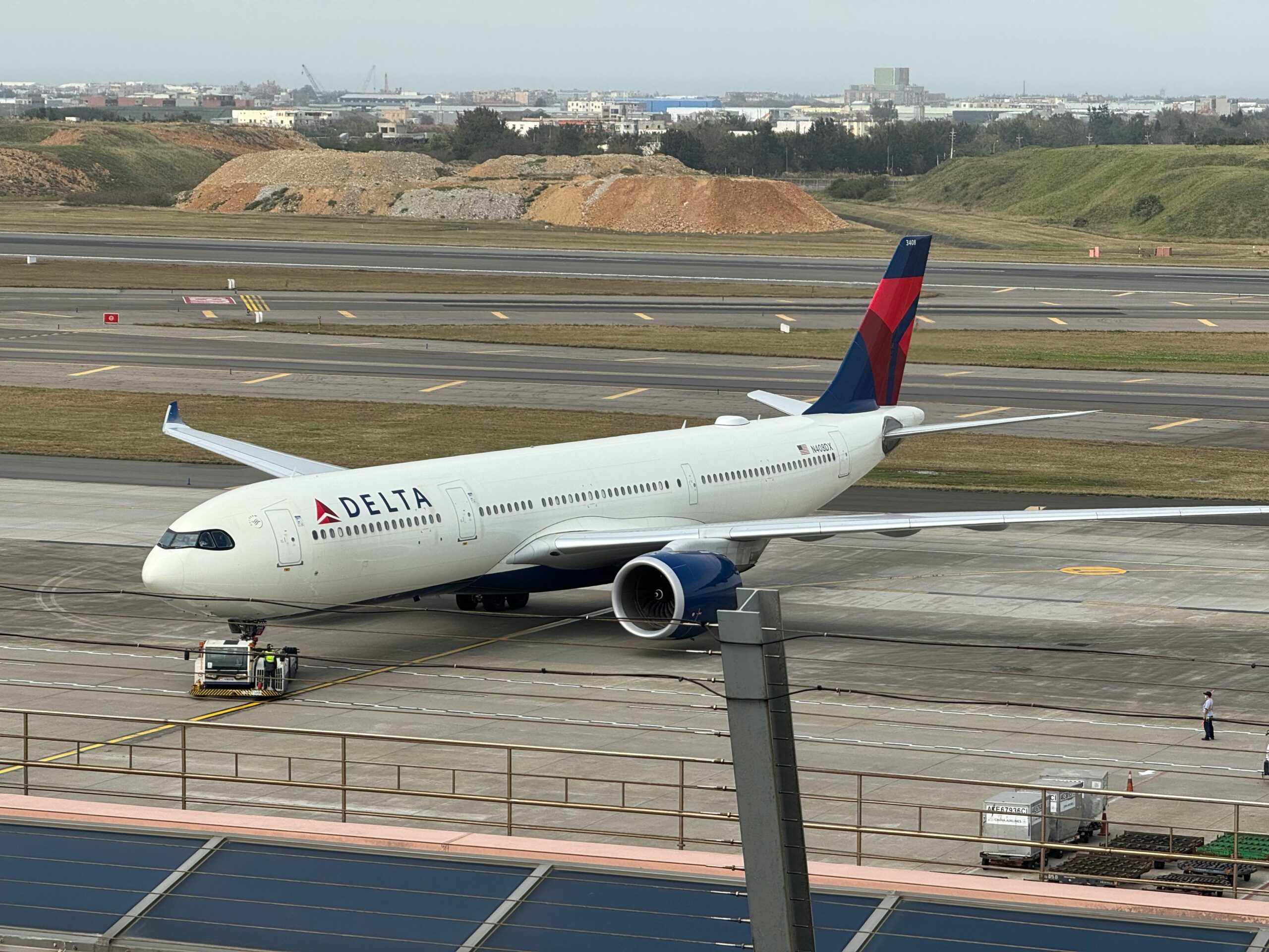 A large white Delta Airlines jetliner sitting on the tarmac at an airport