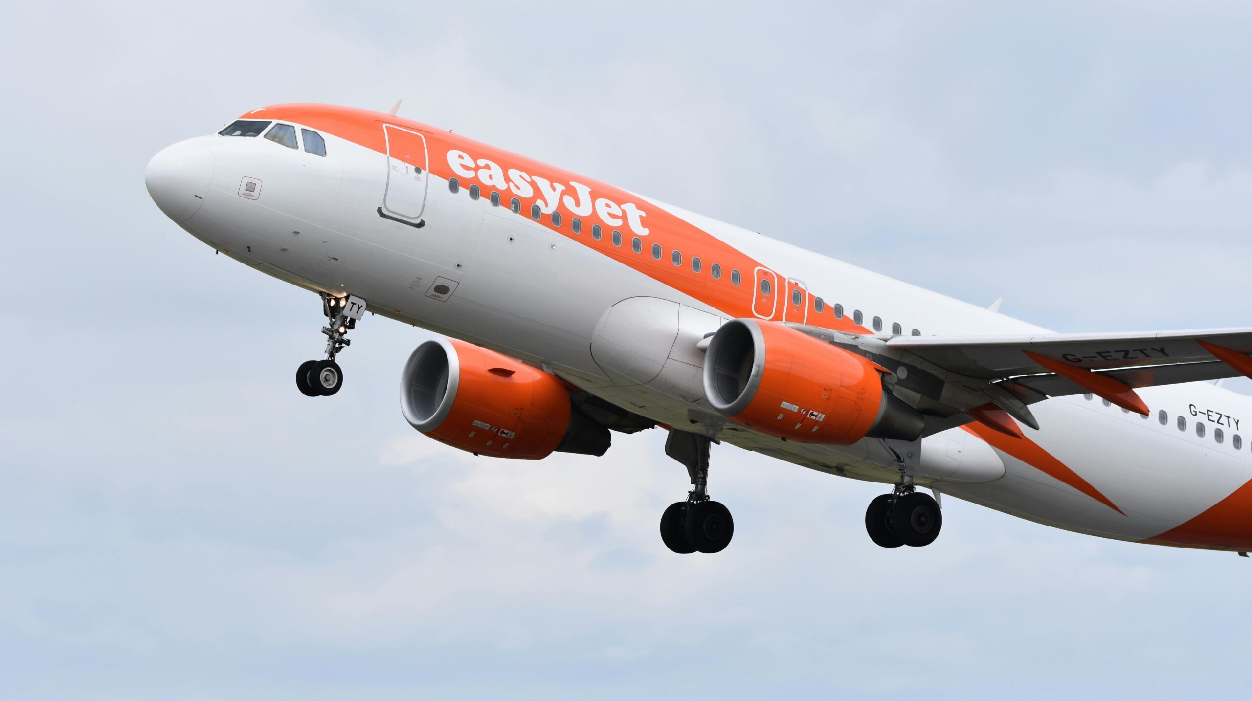 A large EasyJet plane taking off in a cloudy sky
