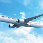 Japan Airlines A350-1000 in flight, pictured among blue skies with some clouds.