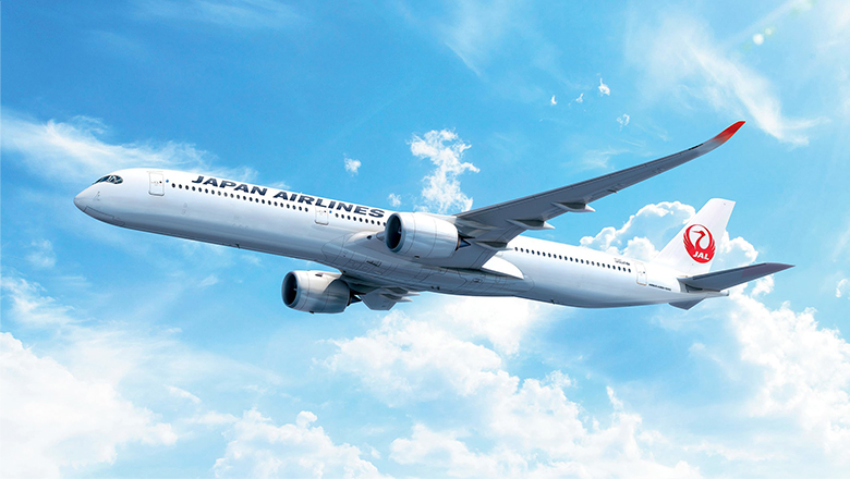Japan Airlines A350-1000 in flight, pictured among blue skies with some clouds.